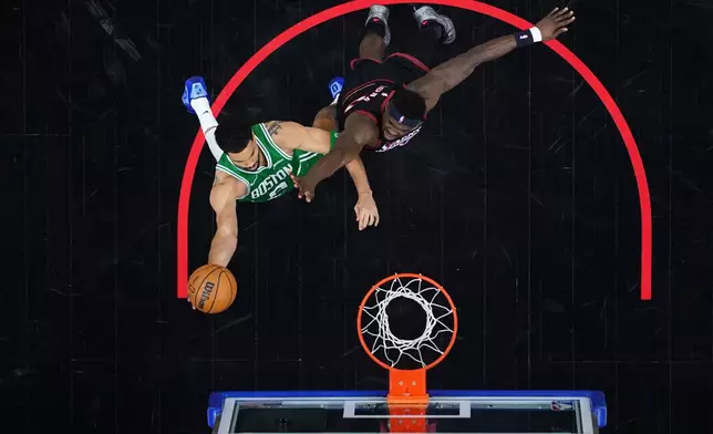 Boston Celtics' Jayson Tatum, left, goes up for a shot past Philadelphia 76ers' Adem Bona during the second half of Game 3 in a first-round NBA playoffs basketball series Friday, April 24, 2026, in Philadelphia. (AP Photo/Matt Slocum)