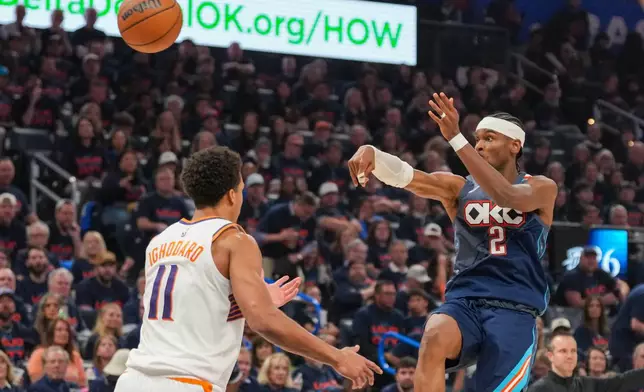 Oklahoma City Thunder guard Shai Gilgeous-Alexander (2) passes over Phoenix Suns forward Oso Ighodaro (11) during the second half in Game 2 of a first-round NBA playoffs basketball series Wednesday, April 22, 2026, in Oklahoma City. (AP Photo/Kyle Phillips)