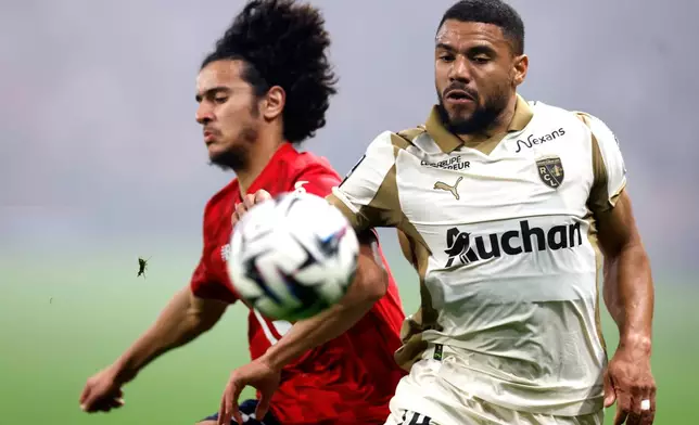 Lille's Ayyoub Bouaddi, left, and Lens' Jonathan Gradit challenge for the ball during the French League One soccer match between Lille and Lens, in Lille, France, Saturday, April 4, 2026. (AP Photo/Jean-Francois Badias)