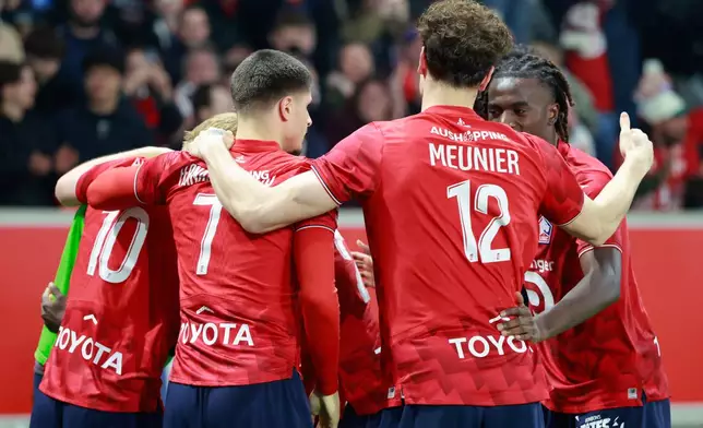 Lille's Felix Correia celebrates with teammates after scoring his side's second goal during the French League One soccer match between Lille and Lens, in Lille, France, Saturday, April 4, 2026. (AP Photo/Jean-Francois Badias)