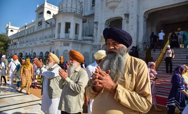 Sikh devotees arrive to pay their respects at the Golden Temple, Sikhism's holiest shrine, on Vaisakhi, a spring harvest festival for Sikhs and Hindus, in Amritsar, India, Tuesday, April 14, 2026. (AP Photo/Prabhjot Gill)