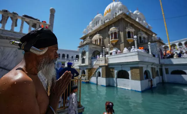 A Sikh pilgrim prays as he attends a ceremony to celebrate Vaisakhi festival, which also marks the New Year in Sikh tradition, at the shrine of Gurdwara Punja Sahib, the second most sacred place for Sikhs, in Hassan Abdal, Pakistan, Tuesday, April 14, 2026. (AP Photo/Anjum Naveed)
