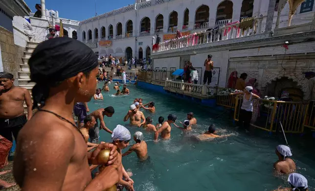 Sikh youth take holy dip in a pool during Vaisakhi festival, which also marks the New Year in Sikh tradition, at the shrine of Gurdwara Punja Sahib, the second most sacred place for Sikhs, in Hassan Abdal, Pakistan, Tuesday, April 14, 2026. (AP Photo/Anjum Naveed)