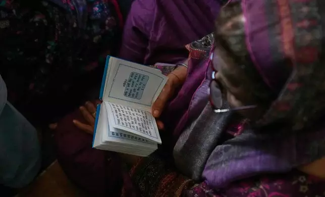 A Sikh pilgrim reads her holy book in a ceremony to celebrate Vaisakhi festival, which also marks the New Year in Sikh tradition, at the shrine of Gurdwara Punja Sahib, the second most sacred place for Sikhs, in Hassan Abdal, Pakistan, Tuesday, April 14, 2026. (AP Photo/Anjum Naveed)