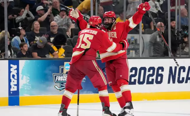 Denver defenseman Kent Anderson, right, celebrates after scoring against Michigan in the second overtime of a semifinal game in the NCAA Frozen Four men's college hockey tournament Thursday, April 9, 2026, in Las Vegas. (AP Photo/John Locher)