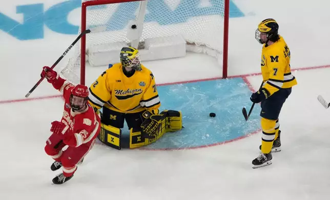 Denver forward Clarke Caswell (25) celebrates after Denver defenseman Cale Ashcroft scored against Michigan goaltender Jack Ivankovic (72) in the second period of a semifinal game of the NCAA Frozen Four men's college hockey tournament Thursday, April 9, 2026, in Las Vegas. (AP Photo/John Locher)