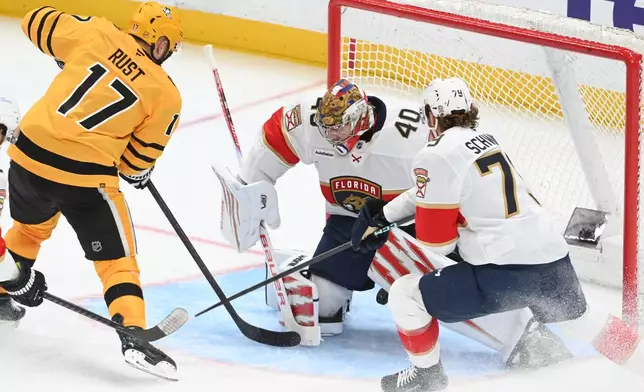 Pittsburgh Penguins right wing Bryan Rust (17) scores a goal between the legs of Florida Panthers goalie Daniil Tarasov (40) as center Cole Schwindt (79) defends during the third period of an NHL hockey game, Sunday, April 5, 2026, in Pittsburgh. (AP Photo/Philip G. Pavely)