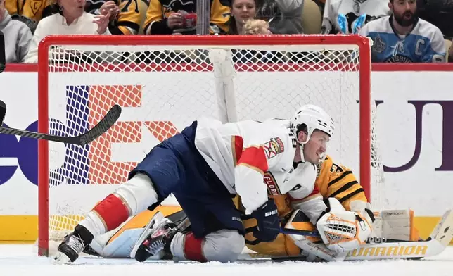 Florida Panthers left wing Matthew Tkachuk (19) wrestles away from Pittsburgh Penguins goalie Arturs Silovs (37) during the second period of an NHL hockey game, Sunday, April 5, 2026, in Pittsburgh. (AP Photo/Philip G. Pavely)