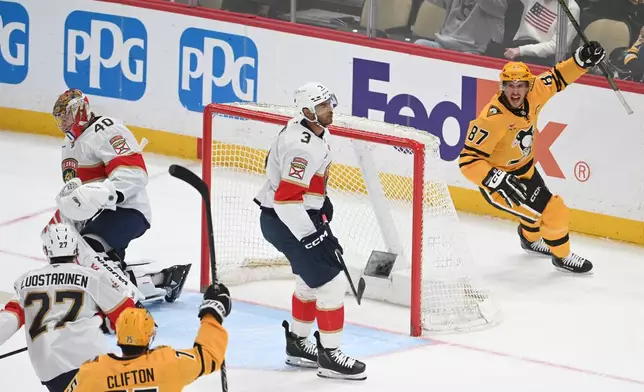 Pittsburgh Penguins center Sidney Crosby (87) celebrates a goal on Florida Panthers goalie Daniil Tarasov (40) as defenseman Connor Clifton (75), center Eetu Luostarinen (27) and defenseman Seth Jones (3) skate nearby during the first period of an NHL hockey game, Sunday, April 5, 2026, in Pittsburgh. (AP Photo/Philip G. Pavely)