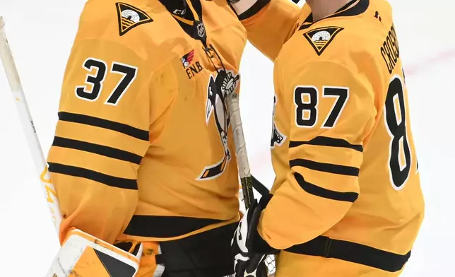 Pittsburgh Penguins center Sidney Crosby (87) congratulates goalie Arturs Silovs (37) after beating the Florida Panthers 5-2, in an NHL hockey game, Sunday, April 5, 2026, in Pittsburgh. (AP Photo/Philip G. Pavely)