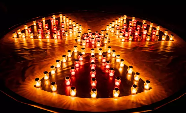 Candles arranged into a radiation hazard symbol at a memorial dedicated to firefighters and workers who died after the 1986 Chornobyl (Chernobyl) nuclear disaster, ahead of its 40th anniversary in Slavutych, Ukraine, Saturday, April 25, 2026. Chornobyl is the Ukrainian name for the city. (AP Photo/Dan Bashakov)