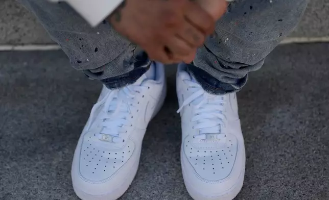 The hands and shoes of Bernard C. are shown during an interview Thursday, April 23, 2026, in Oakland, Calif. (AP Photo/Jeff Chiu)