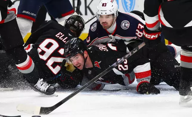 Columbus Blue Jackets right wing Conor Garland (83) and Buffalo Sabres defenseman Mattias Samuelsson (23) watch the puck during the second period of an NHL hockey game Thursday, April 9, 2026, in Buffalo, N.Y. (AP Photo/Jeffrey T. Barnes)