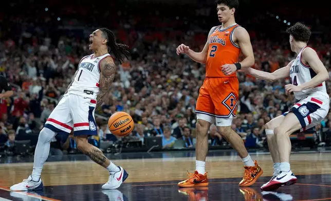 UConn guard Solo Ball (1) celebrates his basket as Illinois guard Andrej Stojakovic (2) looks on during the second half of an NCAA college basketball tournament semifinal game at the Final Four, Saturday, April 4, 2026, in Indianapolis. (AP Photo/Abbie Parr)