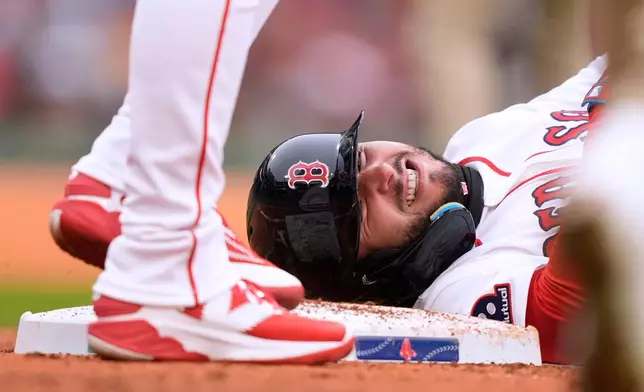 Boston Red Sox right fielder Wilyer Abreu (52) grimaces after being hit by a throw to first base by San Diego Padres pitcher Walker Buehler during the second inning of a baseball game, Sunday, April 5, 2026, in Boston. (AP Photo/Robert F. Bukaty)