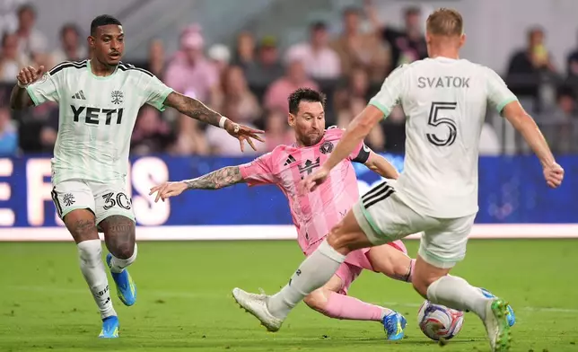 Inter Miami forward Lionel Messi (10) shoots past Austin FC midfielder Joseph Rosales (30) and defender Oleksandr Svatok (5) during the first half of an MLS soccer match, Saturday, April 4, 2026, in Miami. (AP Photo/Rebecca Blackwell)