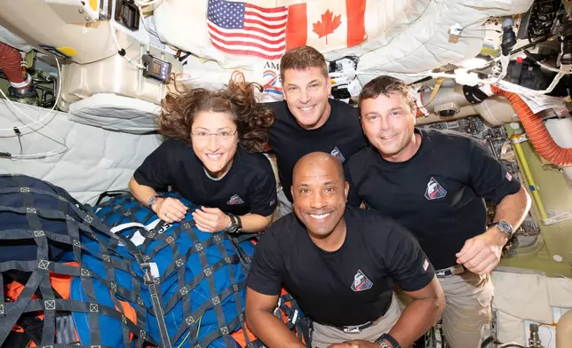In this image provided by NASA, the Artemis II crew, clockwise from left, Mission Specialist Christina Koch, Mission Specialist Jeremy Hansen, Commander Reid Wiseman, and Pilot Victor Glover, pause for a group photo inside the Orion spacecraft on their way home on Wednesday, April 7, 2026. (NASA via AP)