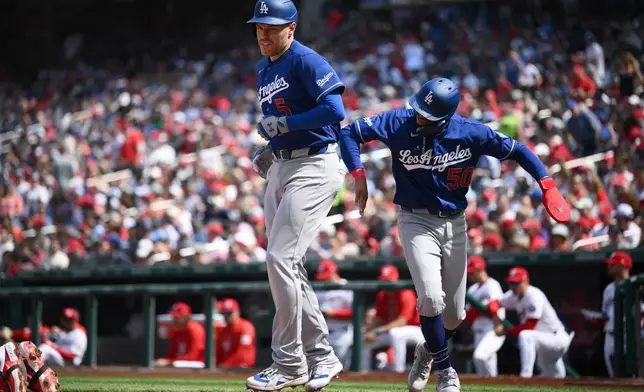 Los Angeles Dodgers' Freddie Freeman celebrates his two-run home run with Mookie Betts (50) during the fifth inning of a baseball game against the Washington Nationals, Friday, April 3, 2026, in Washington. (AP Photo/Nick Wass)
