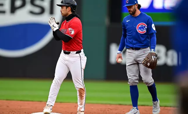 Cleveland Guardians' Steven Kwan, left, reacts after hitting a double in the sixth inning in the second baseball game of a doubleheader against the Chicago Cubs, Sunday, April 5, 2026, in Cleveland. (AP Photo/David Dermer)