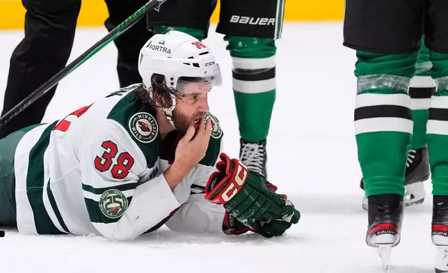 Minnesota Wild right wing Ryan Hartman checks his mouth after a stoppage in play against the Dallas Stars in the second period of an NHL hockey game Thursday, April 9, 2026, in Arlington, Texas. (AP Photo/Tony Gutierrez)