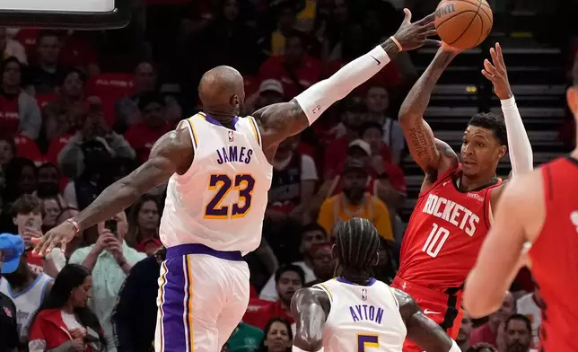 Houston Rockets forward Jabari Smith Jr. (10) looks to pass the ball against Los Angeles Lakers' LeBron James (23) and Deandre Ayton (5) during the first half in Game 4 of a first-round NBA basketball playoffs series, Sunday, April 26, 2026, in Houston. (AP Photo/Karen Warren)