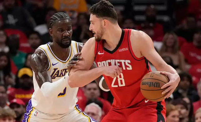 Houston Rockets center Alperen Sengun (28) controls the ball against Los Angeles Lakers center Deandre Ayton (5) during the first half in Game 4 of a first-round NBA basketball playoffs series, Sunday, April 26, 2026, in Houston. (AP Photo/Karen Warren)
