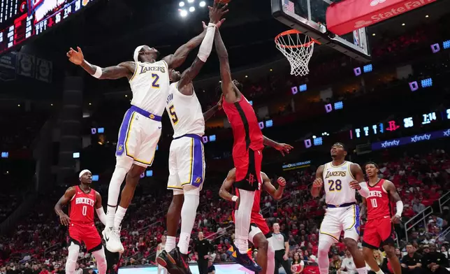 Los Angeles Lakers' Jarred Vanderbilt (2) and Deandre Ayton (5) go up for a rebound against Houston Rockets forward Tari Eason, right, during the first half in Game 4 of a first-round NBA basketball playoffs series, Sunday, April 26, 2026, in Houston. (AP Photo/Karen Warren)