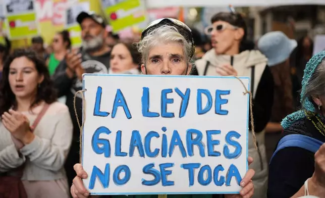 A demonstrator holds a banner that reads in Spanish, "The glacier law must not be touched," as lawmakers debate the Javier Milei government's proposal to reform the glacier protection law, outside Congress in Buenos Aires, Argentina, Wednesday, April 8, 2026. (AP Photo/Rodrigo Abd)