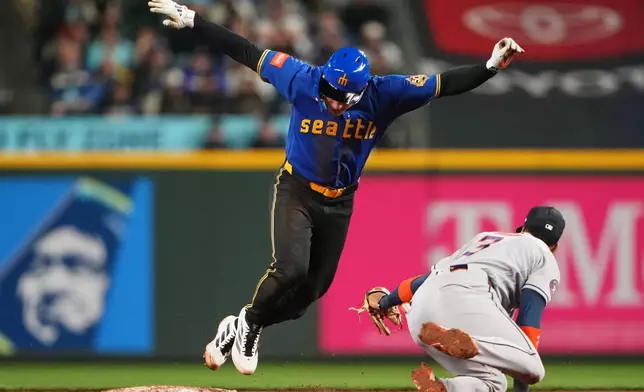 Seattle Mariners' Cole Young is tagged out attempting to steal second by Houston Astros shortstop Jeremy Peña during the fifth inning of a baseball game, Friday, April 10, 2026, in Seattle. (AP Photo/Lindsey Wasson)