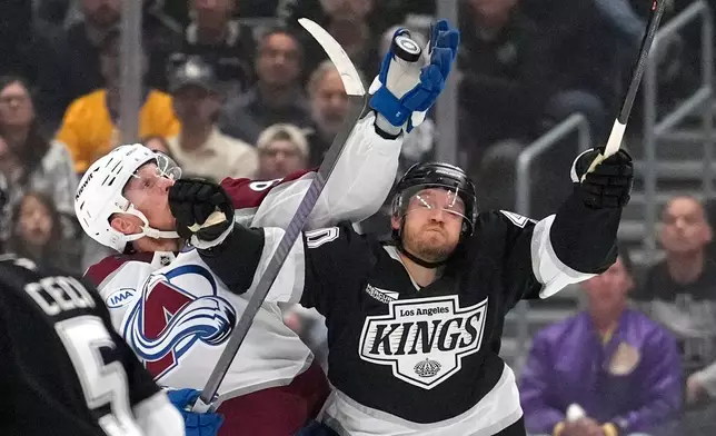 Colorado Avalanche left wing Gabriel Landeskog, left, and Los Angeles Kings right wing Joel Armia reach for the puck during the first period of Game 3 in the first round of the NHL hockey Stanley Cup playoffs Thursday, April 23, 2026, in Los Angeles. (AP Photo/Mark J. Terrill)