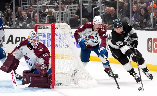 Los Angeles Kings left wing Andrei Kuzmenko, right, takes the puck as Colorado Avalanche defenseman Cale Makar, center reaches in while goaltender Scott Wedgewood watches during the second period of Game 3 in the first round of the NHL hockey Stanley Cup playoffs Thursday, April 23, 2026, in Los Angeles. (AP Photo/Mark J. Terrill)