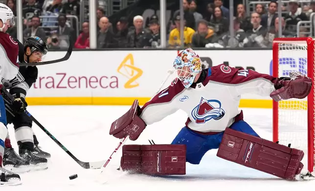 Los Angeles Kings left wing Trevor Moore, center, is hit in the mouth by Colorado Avalanche defenseman Josh Manson, left, as he scores on goaltender Scott Wedgewood, right, during the second period of Game 3 in the first round of the NHL hockey Stanley Cup playoffs Thursday, April 23, 2026, in Los Angeles. (AP Photo/Mark J. Terrill)