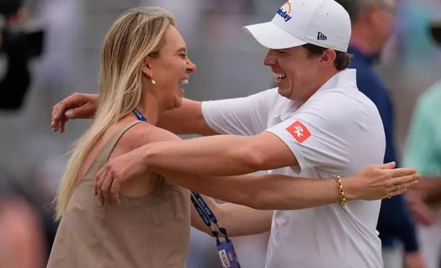 Matt Fitzpatrick, of England, right, hugs his wife Katherine Gaal after winning the RBC Heritage golf tournament Sunday, April 19, 2026, in Hilton Head, S.C. (AP Photo/Mike Stewart)