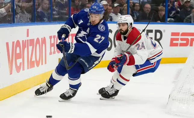 Tampa Bay Lightning defenseman Ryan McDonagh (27) beats Montréal Canadiens center Phillip Danault (24) to a loose puck during the first period in Game 5 of an NHL hockey Stanley Cup first-round playoff series, Wednesday, April 29, 2026, in Tampa, Fla. (AP Photo/Chris O'Meara)