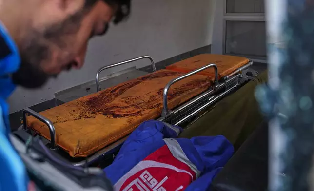 A member of the Nabatiyeh Emergency Services looks inside a damaged ambulance stained with the blood of his colleague, who was killed during a rescue mission in an Israeli airstrike on Wednesday, in Nabatiyeh, southern Lebanon, Friday, April 17, 2026. (AP Photo/Hassan Ammar)