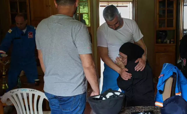 Mohammed Suleiman, chief paramedic of the Nabatiyeh Emergency Services, comforts his niece, Israa Jaber, at the service's temporary center in Nabatiyeh, southern Lebanon, Friday, April 17, 2026. (AP Photo/Hassan Ammar)