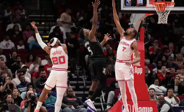 Houston Rockets' Kevin Durant (7) and Josh Okogie (20) defend against Minnesota Timberwolves guard Anthony Edwards (5) during the first half of an NBA basketball game, Friday, April 10, 2026, in Houston. (AP Photo/ Karen Warren)