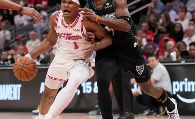 Houston Rockets guard Amen Thompson (1) controls the ball against Minnesota Timberwolves guard Anthony Edwards (5) during the first half of an NBA basketball game, Friday, April 10, 2026, in Houston. (AP Photo/ Karen Warren)