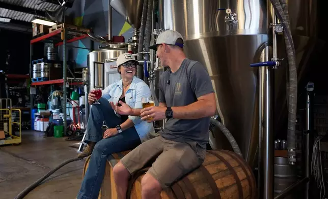 Rancher Alli Fender (left) of Flying F Ranch and Head Brewer Moe Katomski of Viewpoint Brewing Company raise a glass to their unique environmental partnership that keeps spent grains out of landfills and turns them into beef. Photo courtesy of SDFoodies.