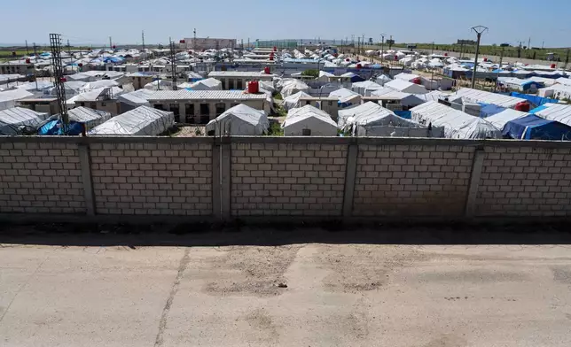 A brick wall surrounds a tent camp housing people with alleged ties to Islamic State militants at Roj Camp in eastern Syria, Friday, April 24, 2026. (AP Photo/Baderkhan Ahmad)