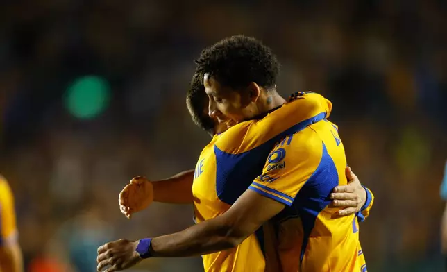 Ozziel Herrera of Mexico's Tigres, right, is congratulated after scoring his side's opening goal against the United States' Seattle Sounders during a CONCACAF Champions Cup quarterfinal first leg soccer match in Monterrey, Mexico, Wednesday, April 8, 2026. (AP Photo/Jorge Mendoza)