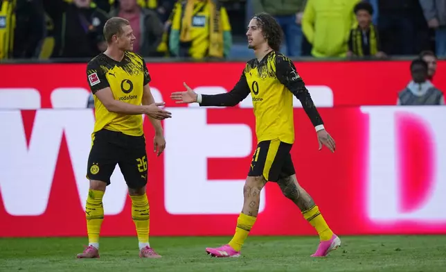 Dortmund's Fabio Silva, right, celebrates with Julian Ryerson after scoring his side's fourth goal during the German Bundesliga soccer match between Borussia Dortmund and SC Freiburg in Dortmund, Germany, Sunday, April 26, 2026. (AP Photo/Martin Meissner)