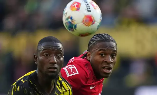 Dortmund's Serhou Guirassy, left, and Freiburg's Bruno Ogbus challenge for the ball during the German Bundesliga soccer match between Borussia Dortmund and SC Freiburg in Dortmund, Germany, Sunday, April 26, 2026. (AP Photo/Martin Meissner)