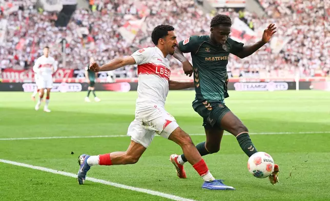 Bremen's Karim Coulibaly, right, and Stuttgart's Tiago Tomas, left, challenge for the ball during the German Bundesliga soccer match between VfB Stuttgart and Werder Bremen in Stuttgart, Germany, Sunday, April 26, 2026. (Bernd Weissbrod/dpa via AP)