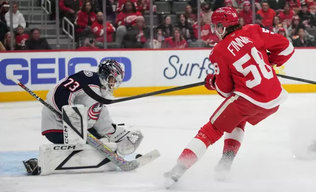 Columbus Blue Jackets goaltender Jet Greaves (73) stops a Detroit Red Wings center Emmitt Finnie (58) shot in the second period of an NHL hockey game Tuesday, April 7, 2026, in Detroit. (AP Photo/Paul Sancya)