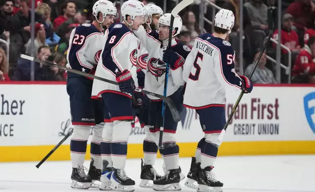 Columbus Blue Jackets defenseman Zach Werenski (8) celebrates his goal with teammates against the Detroit Red Wings in the second period of an NHL hockey game Tuesday, April 7, 2026, in Detroit. (AP Photo/Paul Sancya)