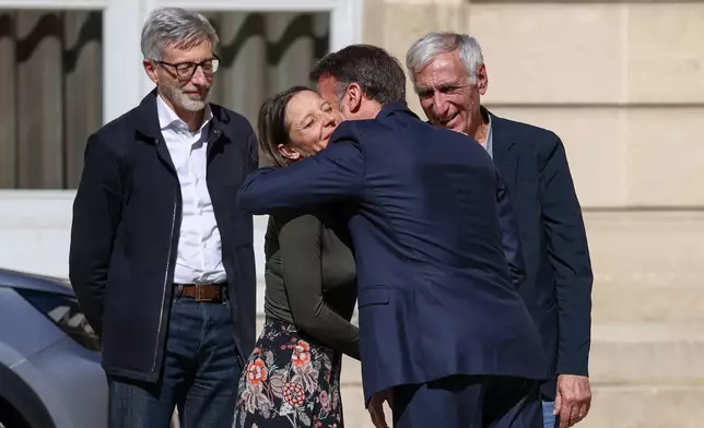 French President Emmanuel Macron, centre right, greets Cecile Kohler, a French national who was freed by Iran with Jacques Paris, right, after three and a half years in detention, next to French ambassador to Iran Pierre Cochard at the Elysee Palace in Paris, France, April 8, 2026. (Tom Nicholson/Pool Photo via AP)