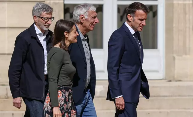 French President Emmanuel Macron, right, walks with Jacques Paris, second from right, and Cecile Kohler, third from right, French nationals who was freed by Iran with Cecile Kohler after three and a half years in detention, and French ambassador to Iran Pierre Cochard, left, at the Elysee Palace in Paris, France, April 8, 2026. (Tom Nicholson/Pool Photo via AP)
