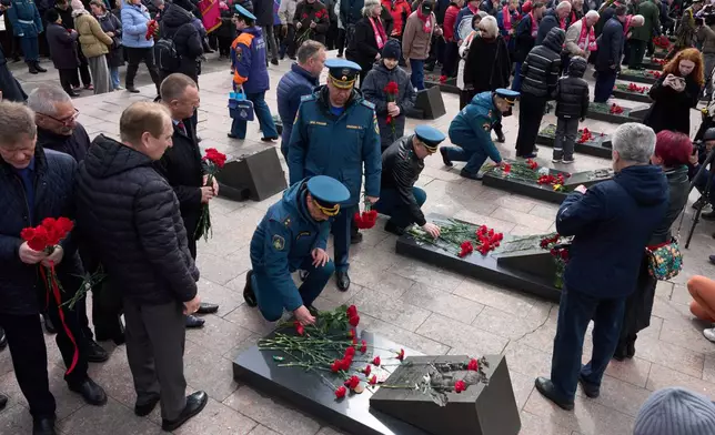 Russian Emergency Ministry troops and veterans lay flowers at the graves of firefighters at the Mitinskoye Cemetery where several victims of the Chernobyl nuclear disaster are buried, marking the 40th anniversary of the explosion and fire at the Chernobyl nuclear power plant in Ukraine, outside Moscow, Sunday, April 26, 2026. (AP Photo/Alexander Zemlianichenko)