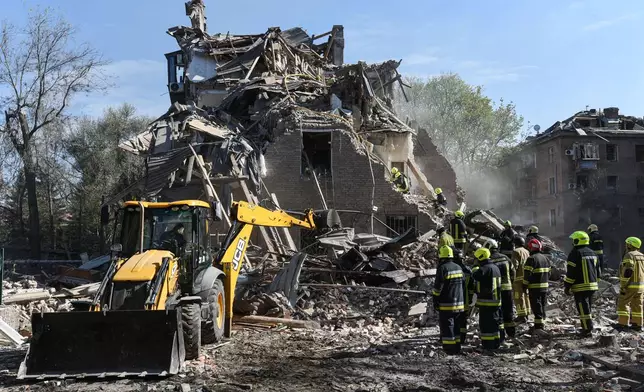 Rescue workers clear the rubble of a residential building destroyed by a Russian strike, in Dnipro, Ukraine, Saturday, April 25, 2026. (AP Photo/Mykola Synelnykov)